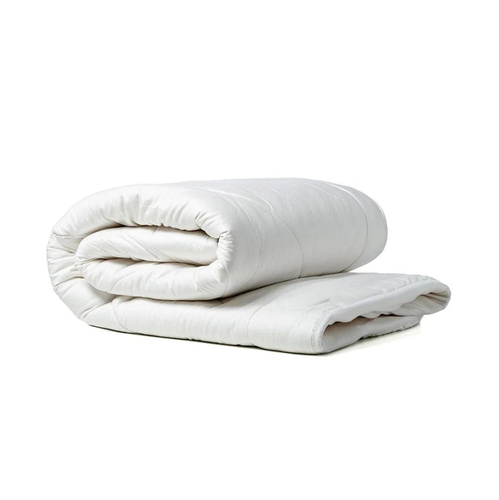 Folded white comforter on a white background