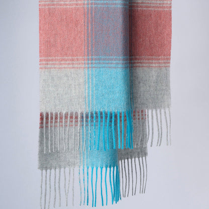 A plaid wool scarf with plaid in coral, blue, and gray colours, displayed neatly with fringes at the bottom.