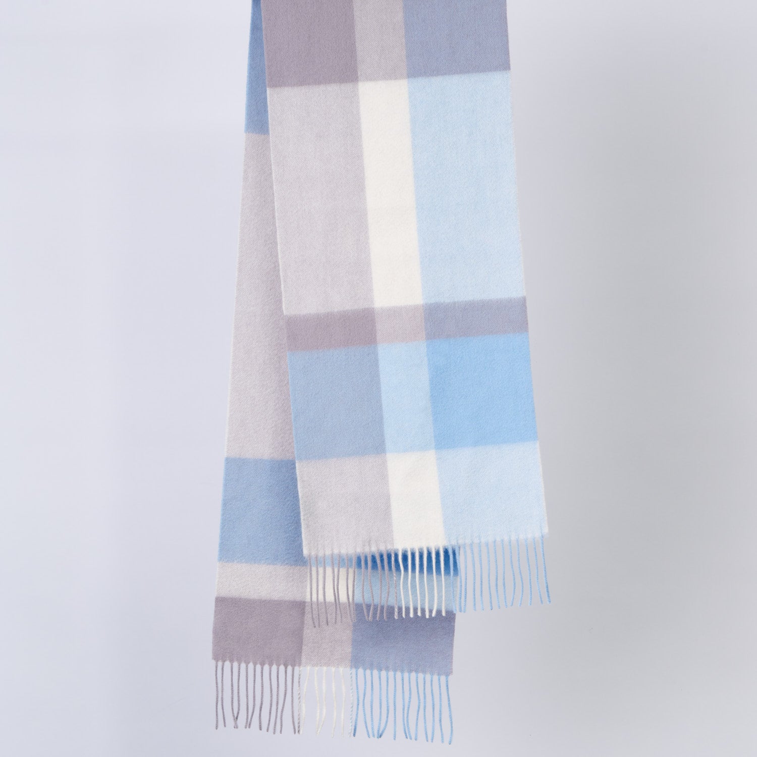 Plaid wool scarf with blue, gray, and white colours on a light gray background