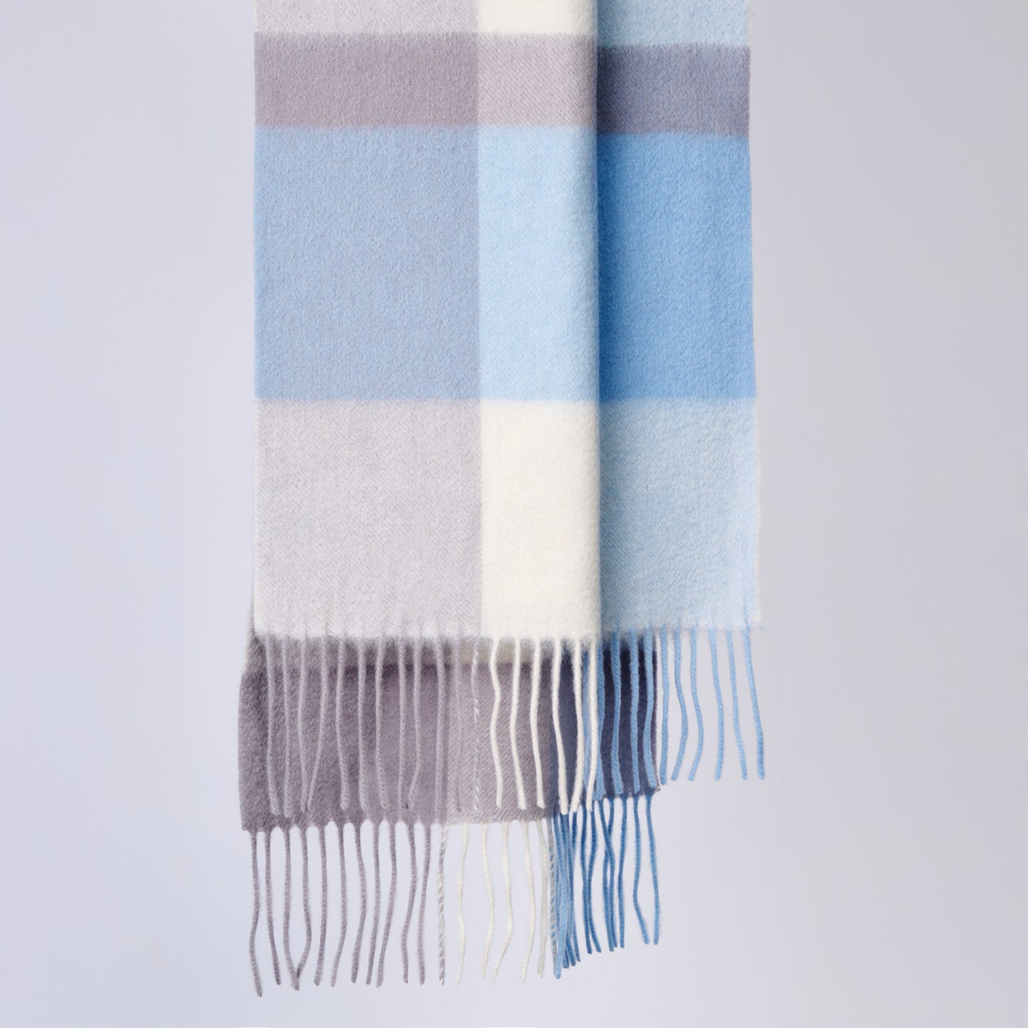 Plaid wool scarf with blue, gray, and white stripes on a light gray background