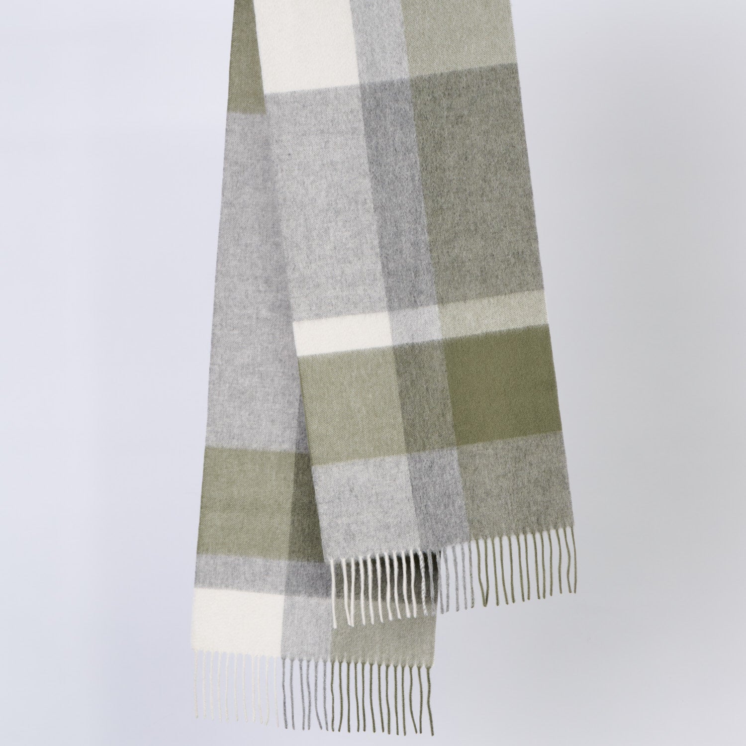 Plaid wool scarf with green, gray, and white colors on a light gray background