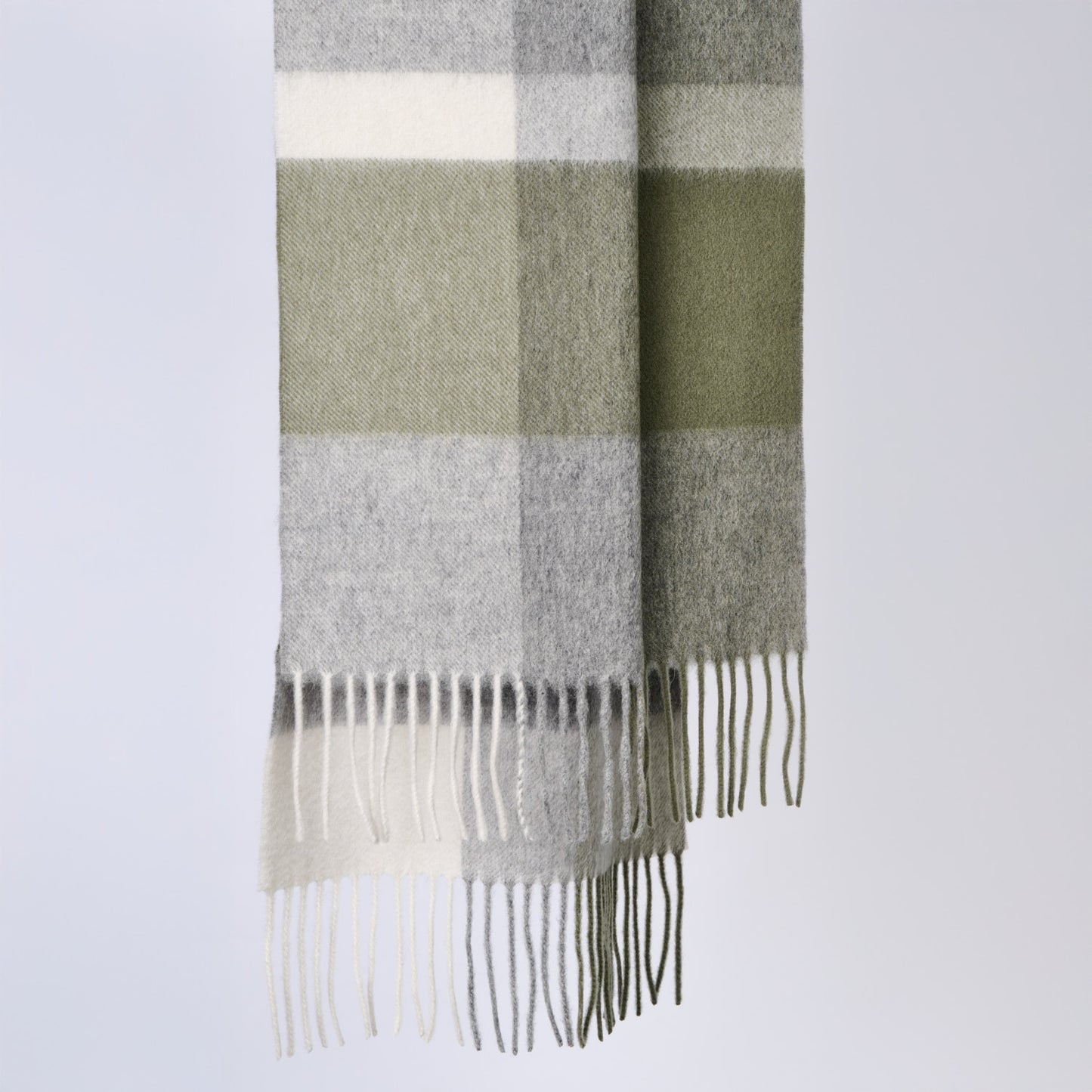 Plaid wool scarf with fringe details on a light gray background
