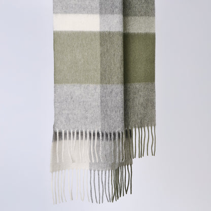 Plaid wool scarf with fringe details on a light gray background