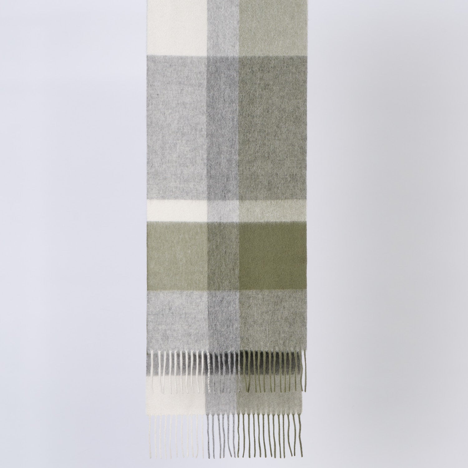 Plaid wool scarf with green, gray, and white colors on a light gray background