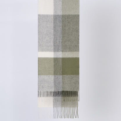 Plaid wool scarf with green, gray, and white colors on a light gray background