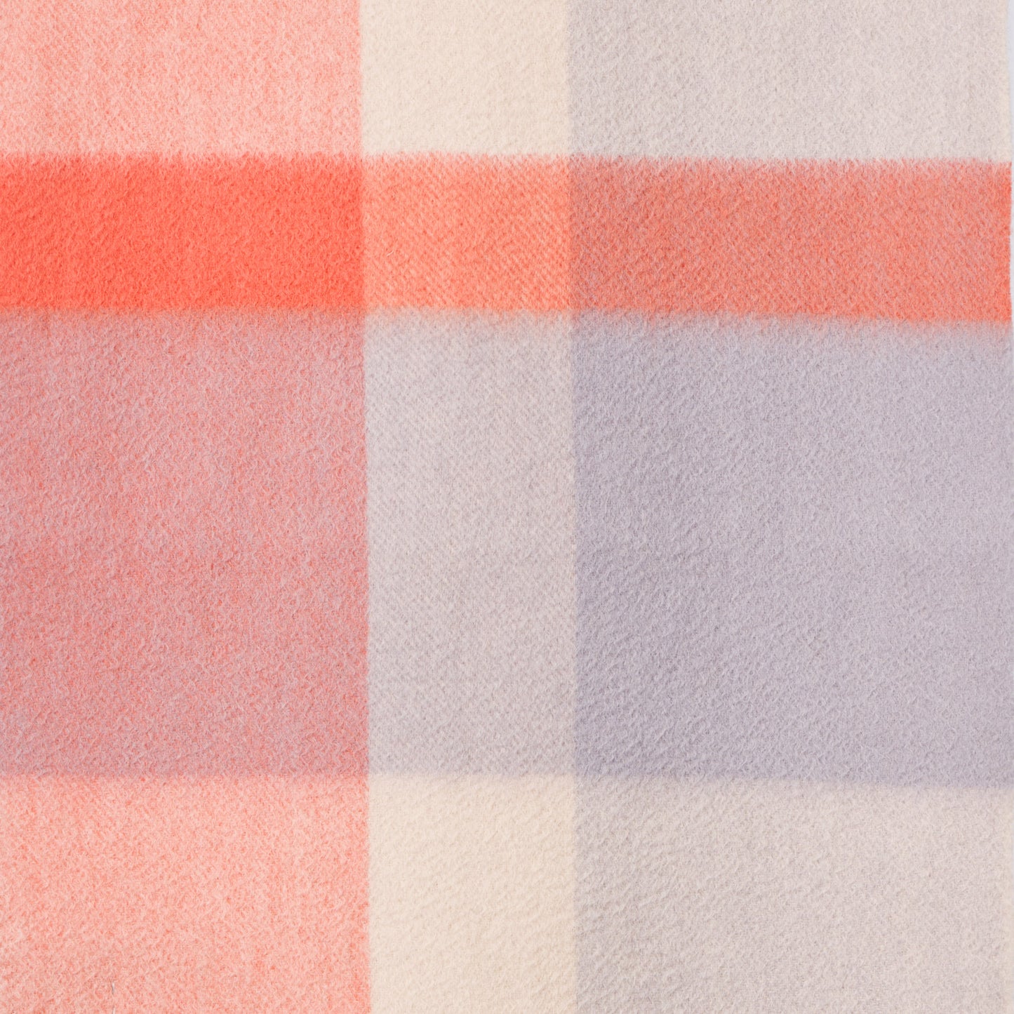 Close-up of a plaid wool fabric with orange, purple, and white colours. 