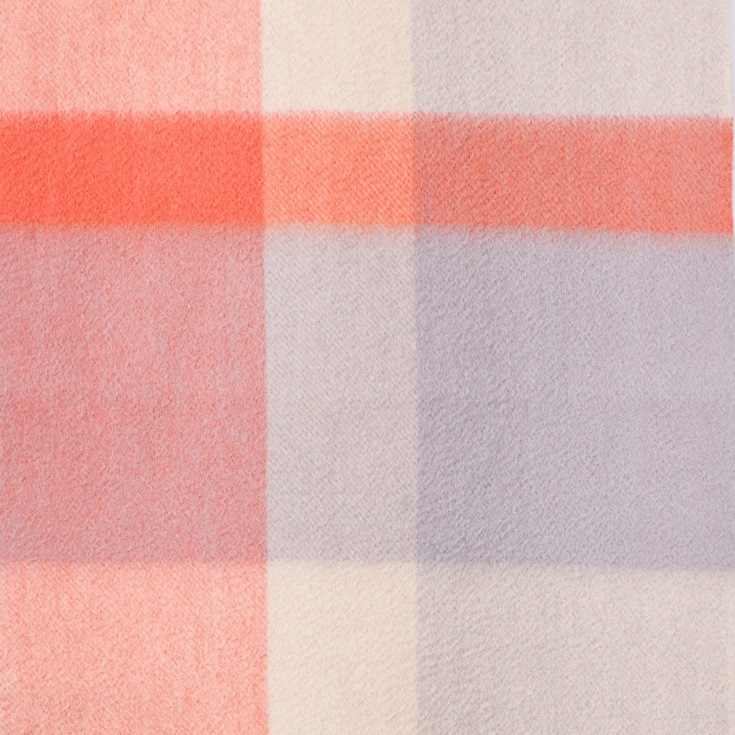Close-up of a plaid wool fabric with orange, purple, and white colours. 