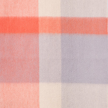 Close-up of a plaid wool fabric with orange, purple, and white colours. 
