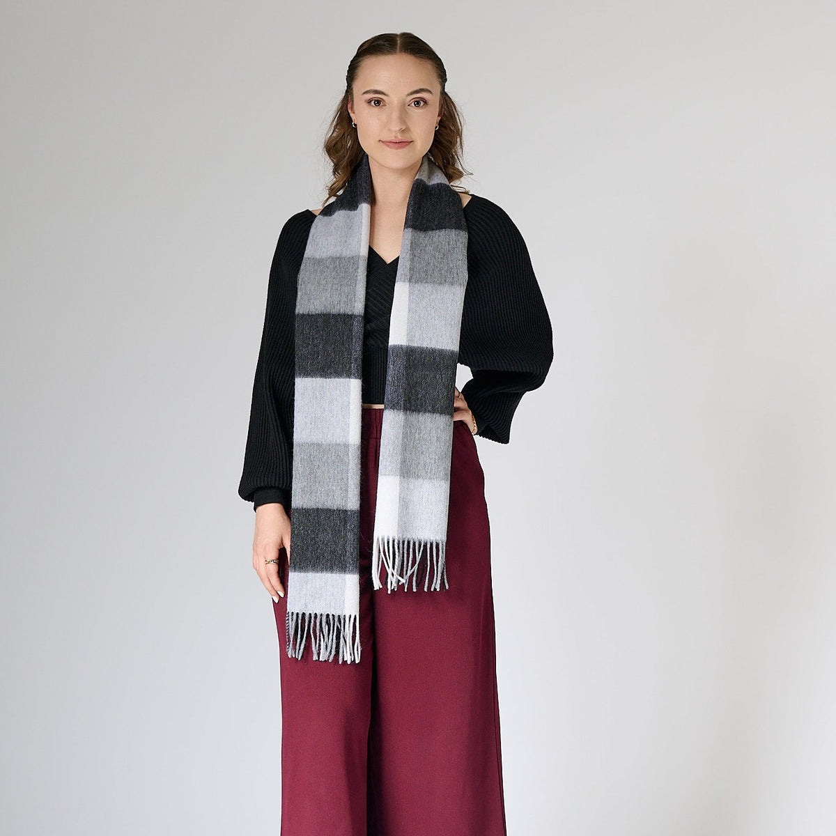 Woman wearing a black and white checkered scarf on a plain background