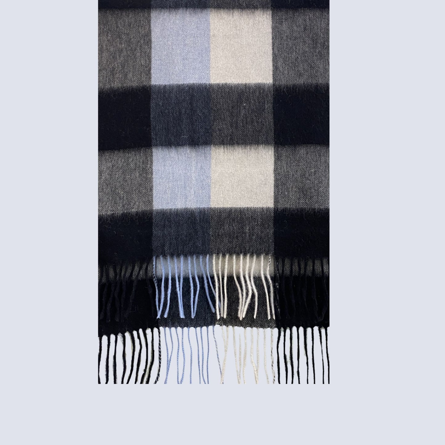 Plaid scarf with black, gray, and white colors on a light gray background