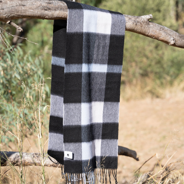 Black and white checkered scarf draped over a branch with a natural background