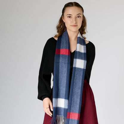 Woman wearing a blue, red, and white checkered scarf against a plain background