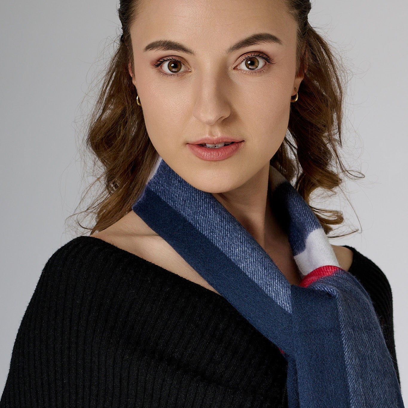 Woman wearing a blue scarf with a neutral background