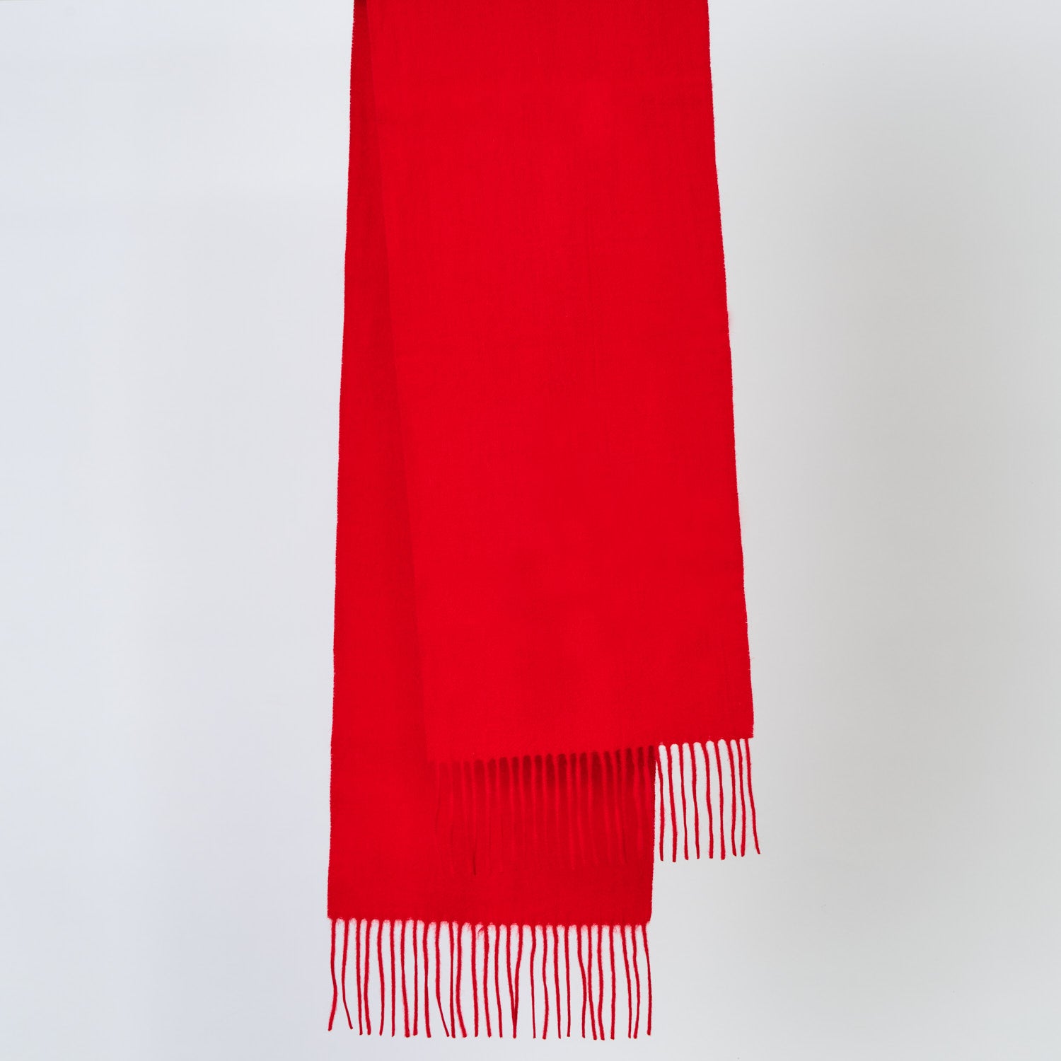 Red scarf with fringes on a light gray background
