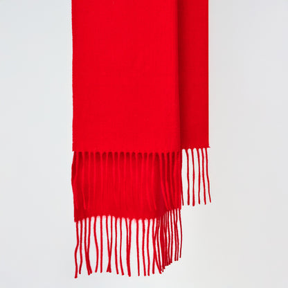 Red scarf with fringes on a light gray background