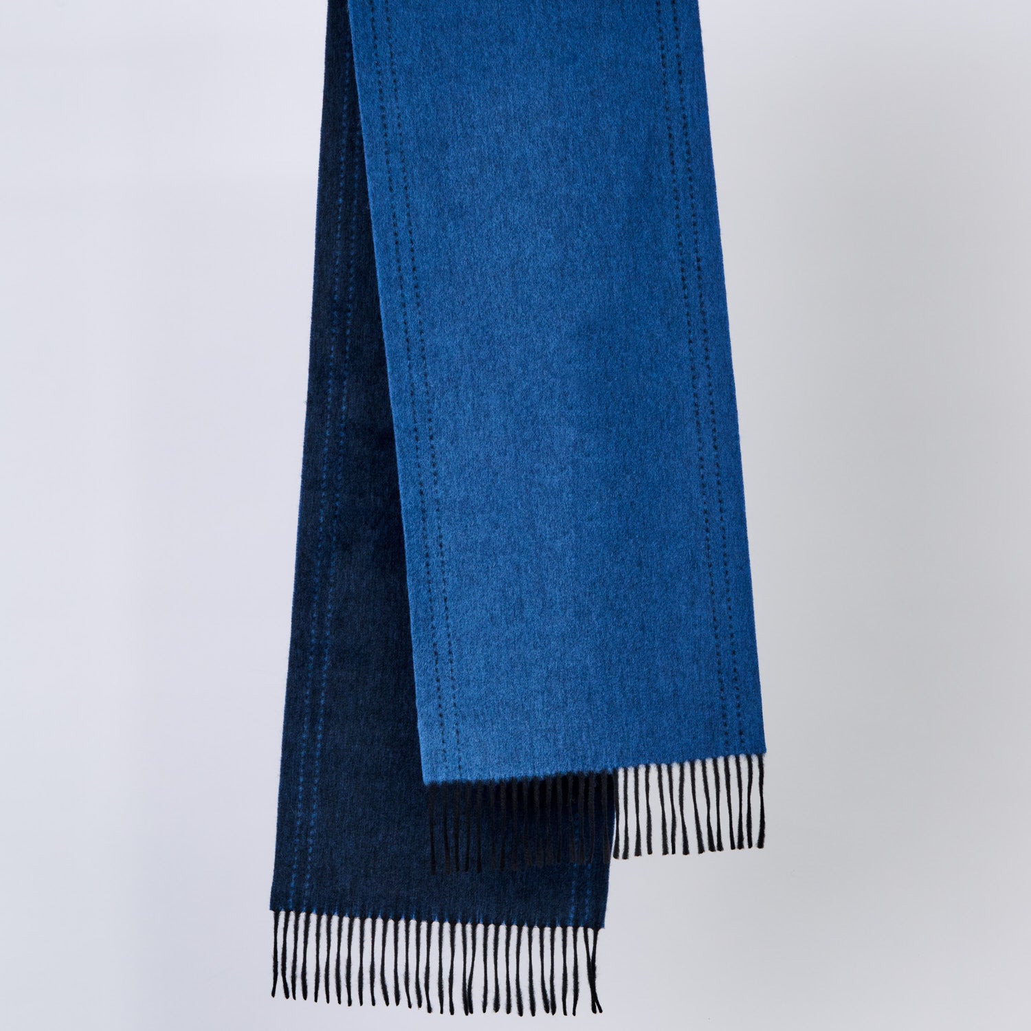 blue scarves with fringes on a light gray background
