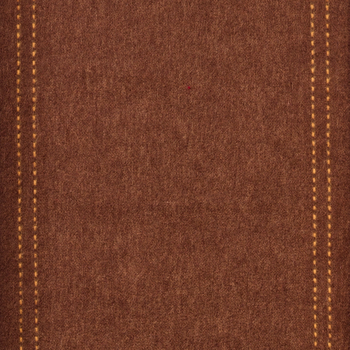 Close-up of brown wool fabric with yellow stitching