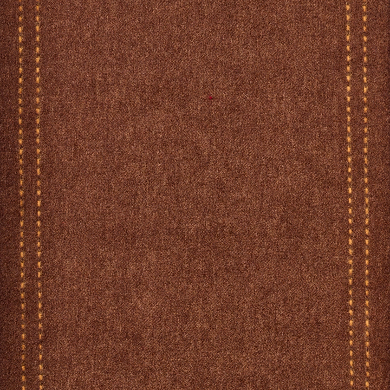 Close-up of brown wool fabric with yellow stitching