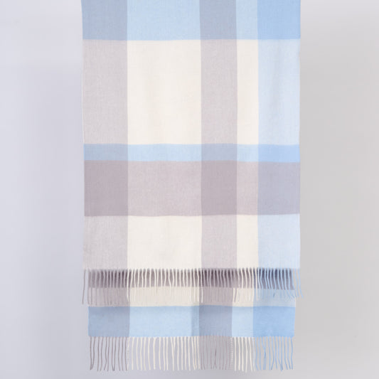 Plaid wool shawl with blue and white stripes on a light gray background