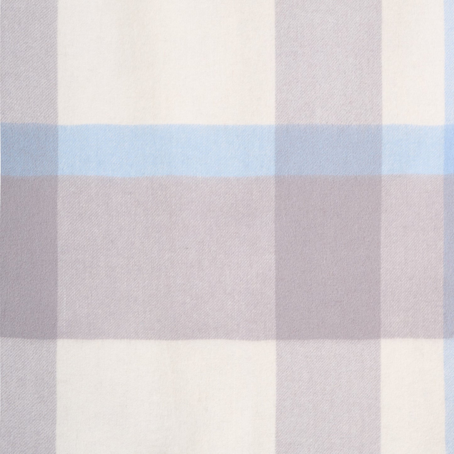 Close-up flat lay of a plaid merino wool shawl, showcasing its soft texture and plaid pattern