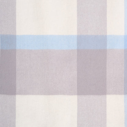 Close-up flat lay of a plaid merino wool shawl, showcasing its soft texture and plaid pattern