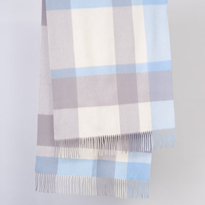 Plaid wool shawl with blue and gray pattern on a light gray background