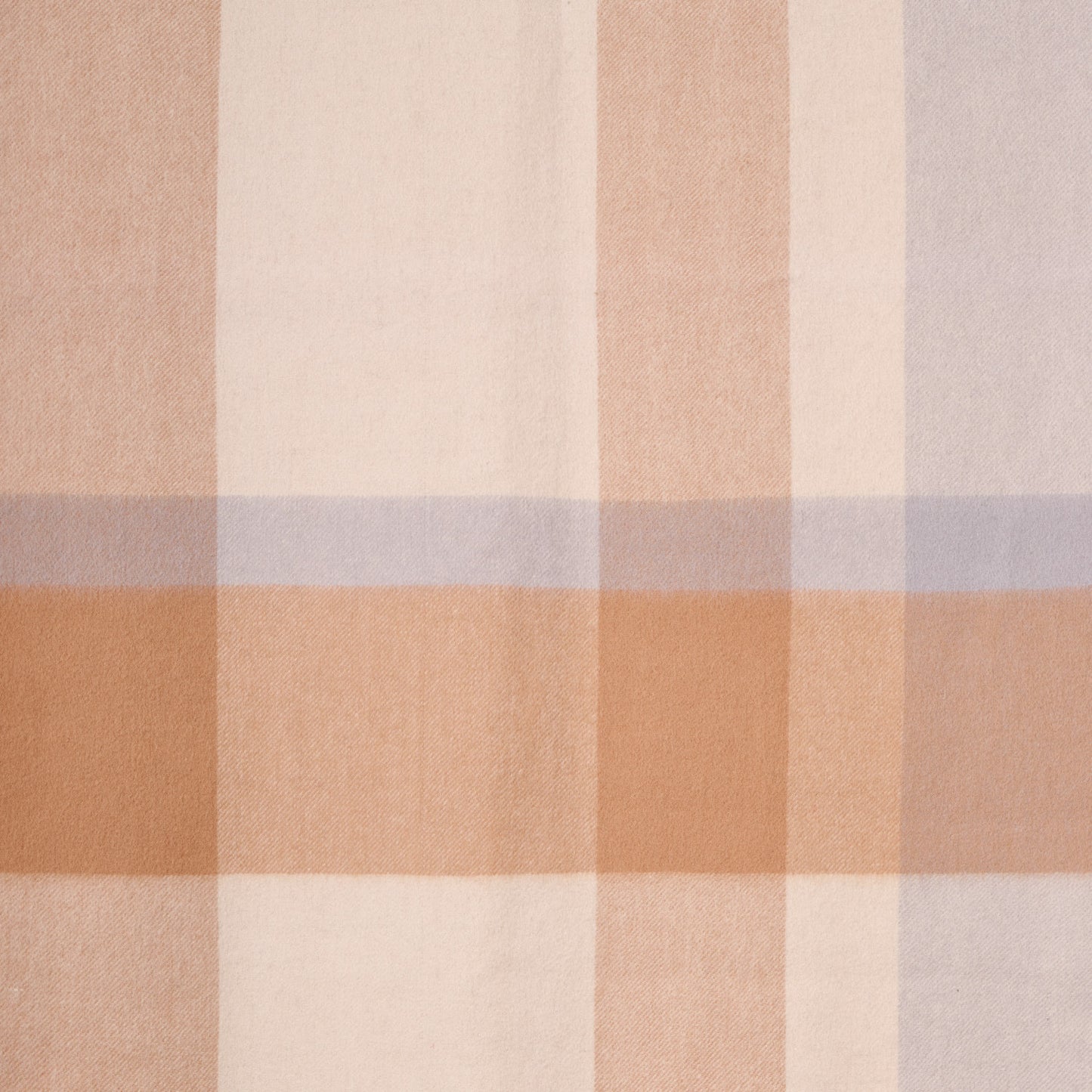 Close-up flat lay of a plaid merino wool shawl, showcasing its soft texture and plaid pattern