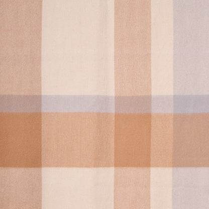 Close-up flat lay of a plaid merino wool shawl, showcasing its soft texture and plaid pattern