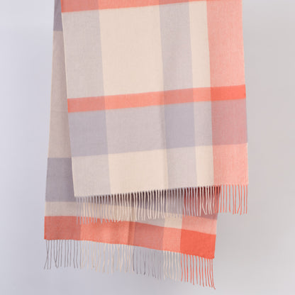 Plaid wool scarf with pink, gray, and beige colours on a light gray background