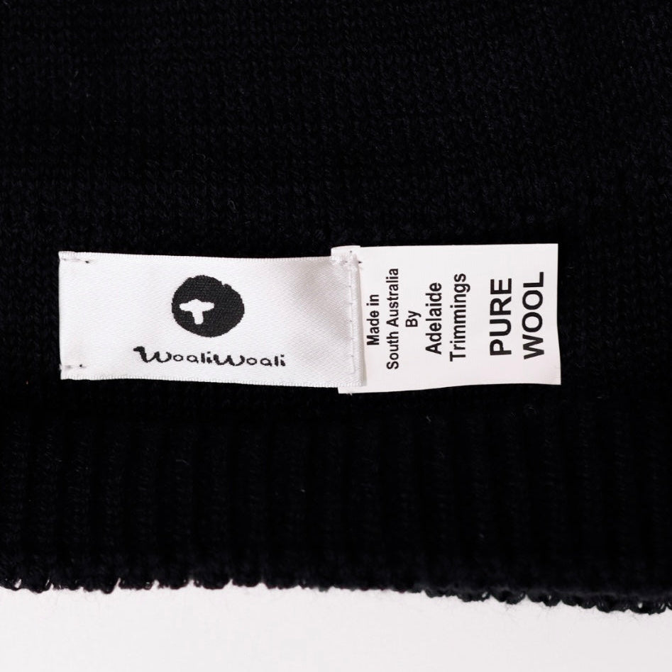 Black fabric with a 'wooliwooli' label indicating 'Pure Wool'.