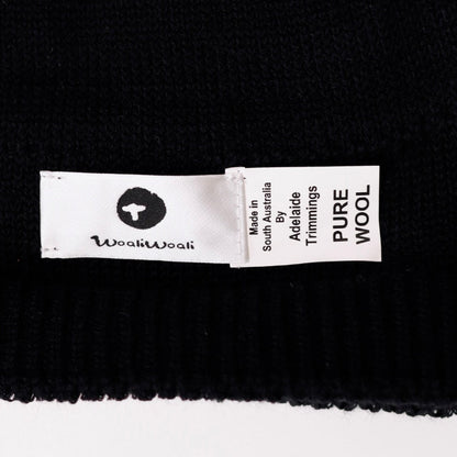 Black fabric with a 'wooliwooli' label indicating 'Pure Wool'.