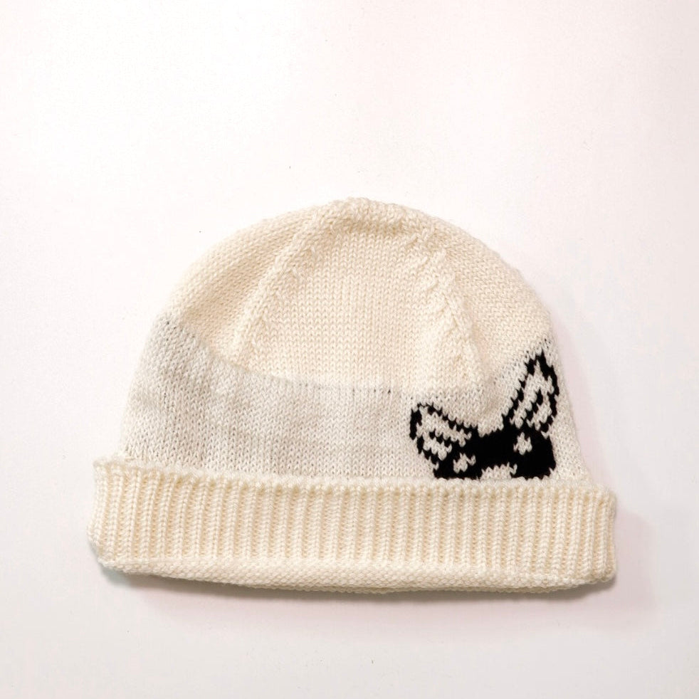 White knit beanie with black bird design on a white background