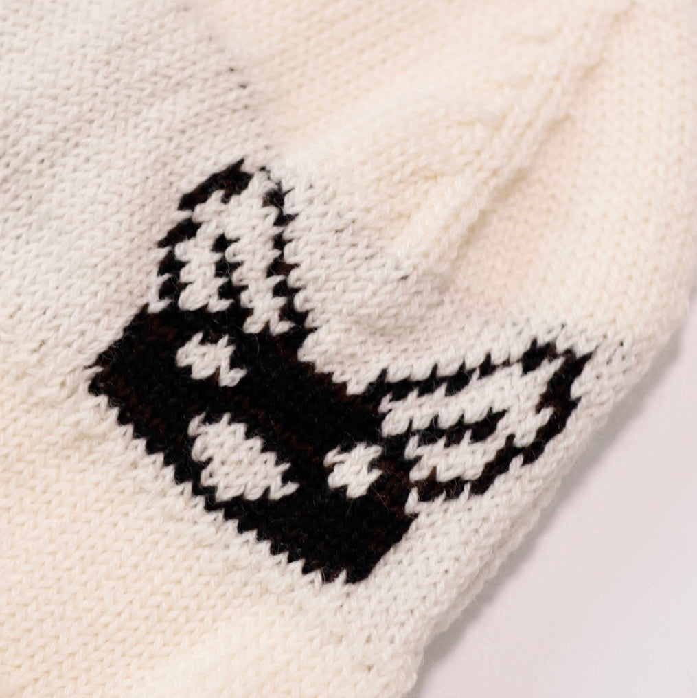 White knitted item with black butterfly design on a white background