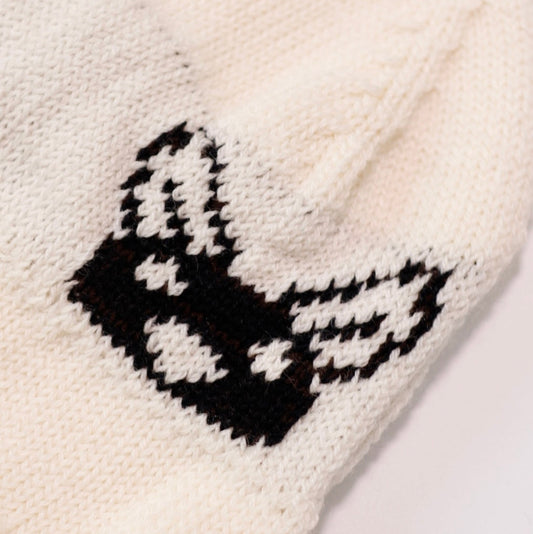 White knitted item with black butterfly design on a white background