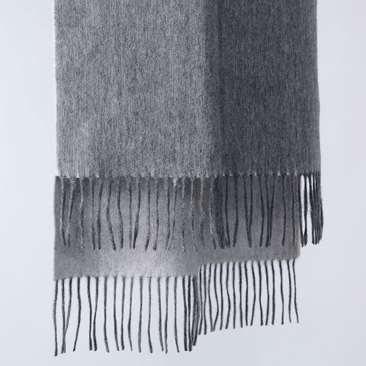 Double-sided light gray scarf with fringes on a light gray background
