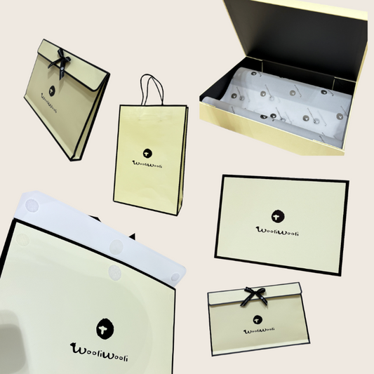 A collection of gift wrapping options including a beige envelope, a black and beige gift box, and a white card with a logo.