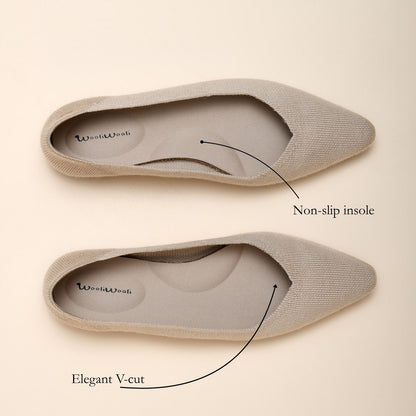Beige pointed-toe flats with non-slip insole and elegant V-cut design on a beige background.