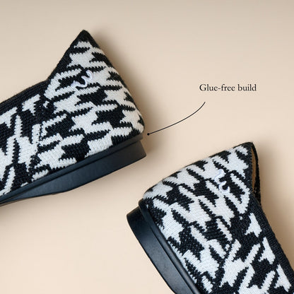 Black and white patterned shoes with a glue-free build label on a beige background