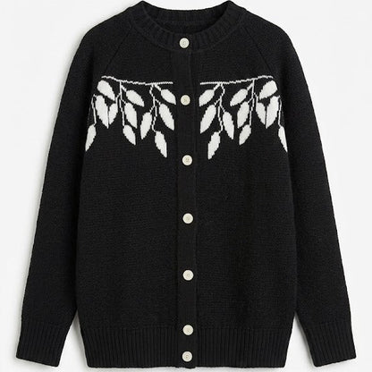 Black cardigan with white button details and leaf pattern on a white background